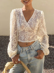 White lace sheer long sleeve wrap blouse with floral applique detail and bell sleeves
