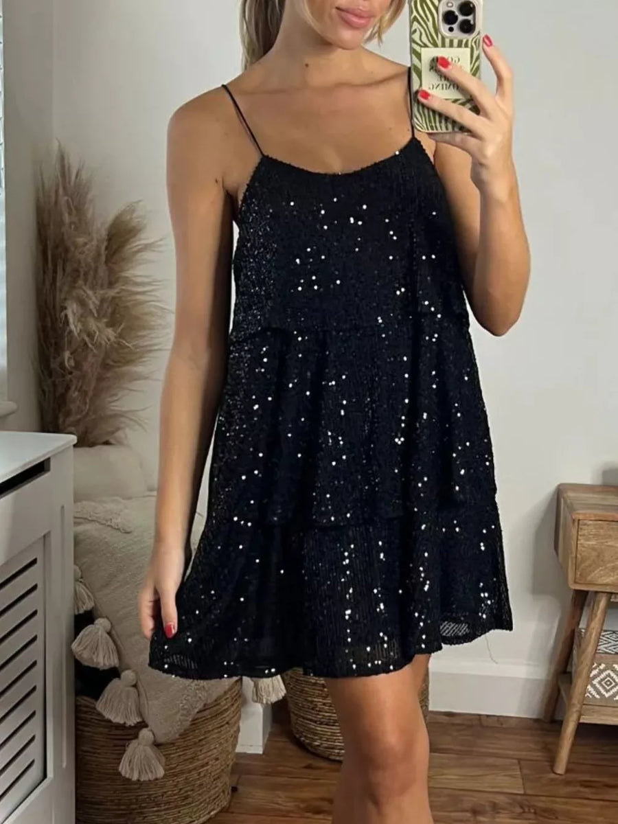 Black sequin mini dress with spaghetti straps and tiered skirt.