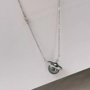 Celestial pearl and silver pendant necklace with planet ring detail.