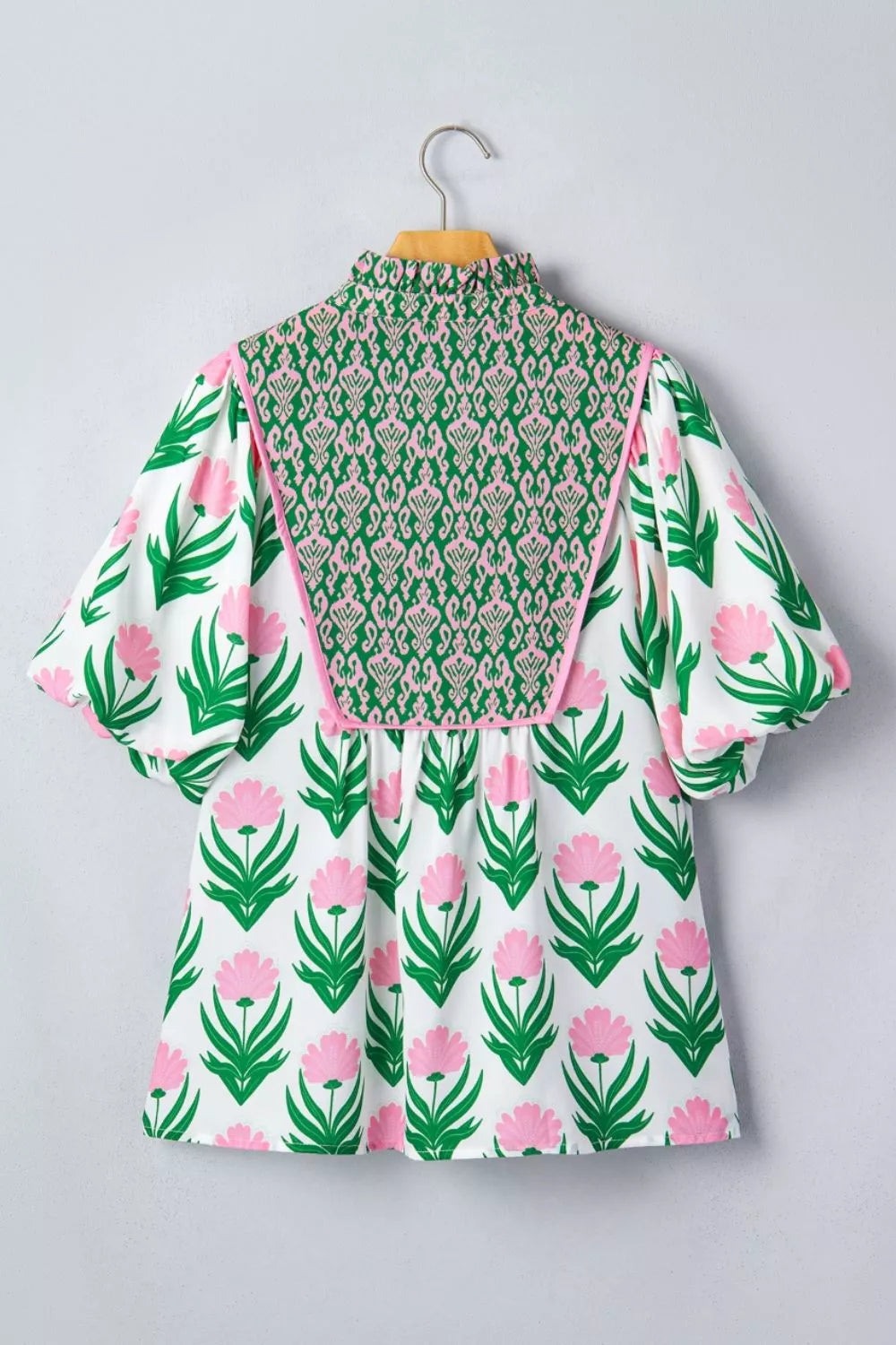 White polyester blouse with pink floral print, green patterned yoke, and puff sleeves.
