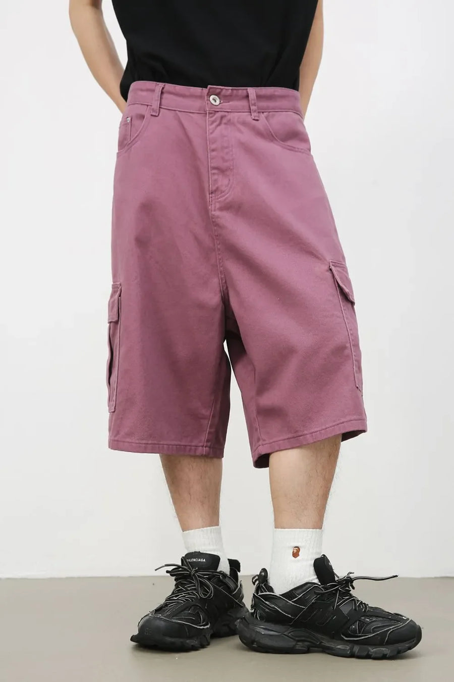 Magenta baggy cargo Bermuda shorts with buttoned front and side pockets.