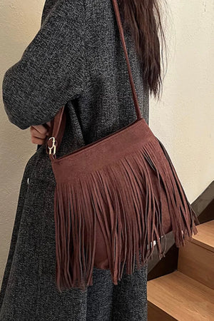 Brown suede crossbody bag with fringe detail and gold hardware.