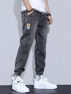 Gray jogger jeans with drawstring, pockets, and patch detail.