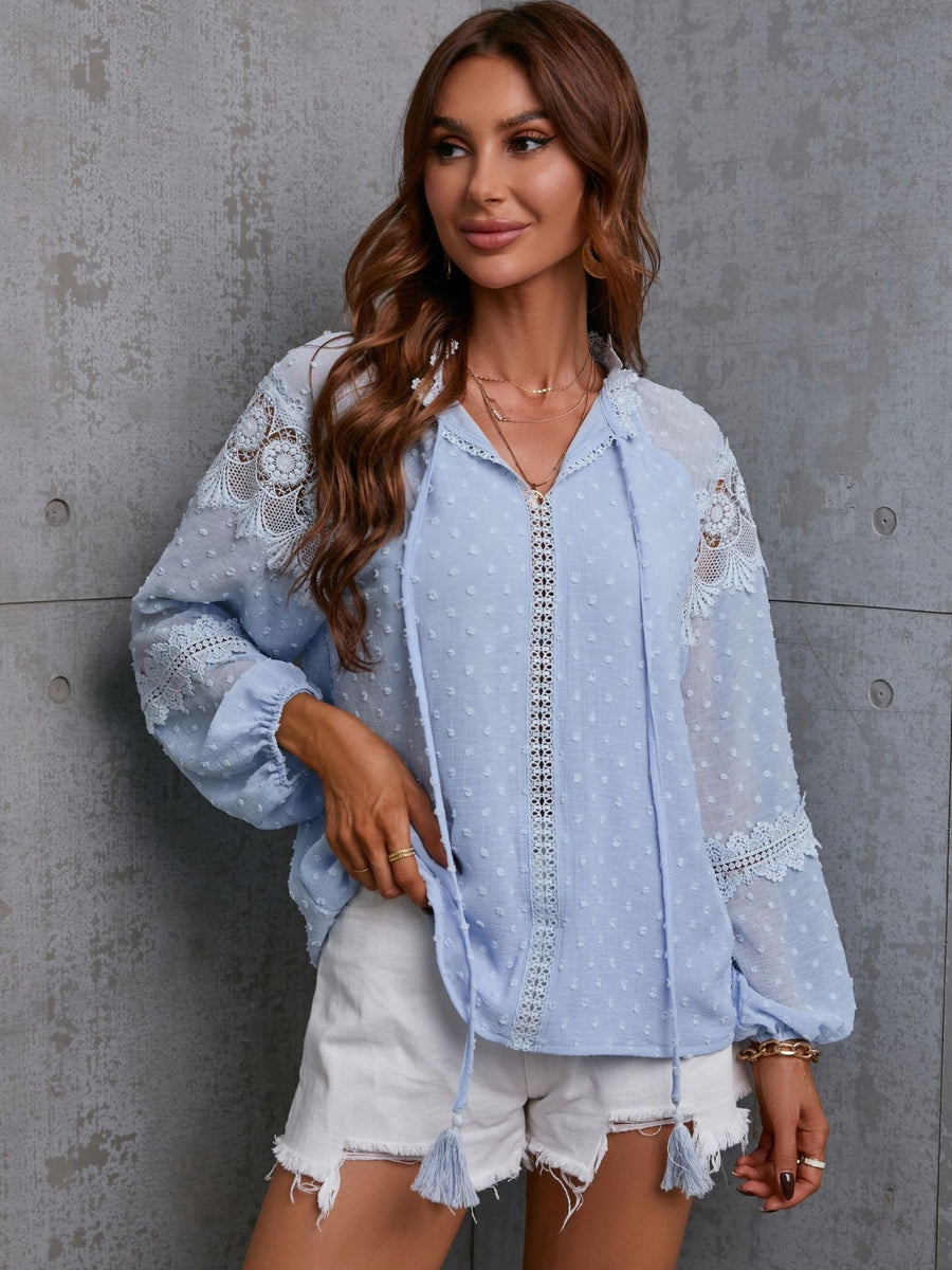 Misty blue textured blouse with lace trim and tie neck detail, long sleeves.