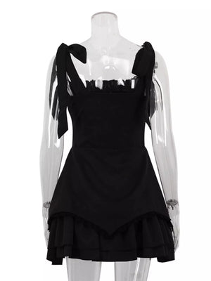 Black mini dress with tie straps, ruffled neckline, and tiered ruffled hem.