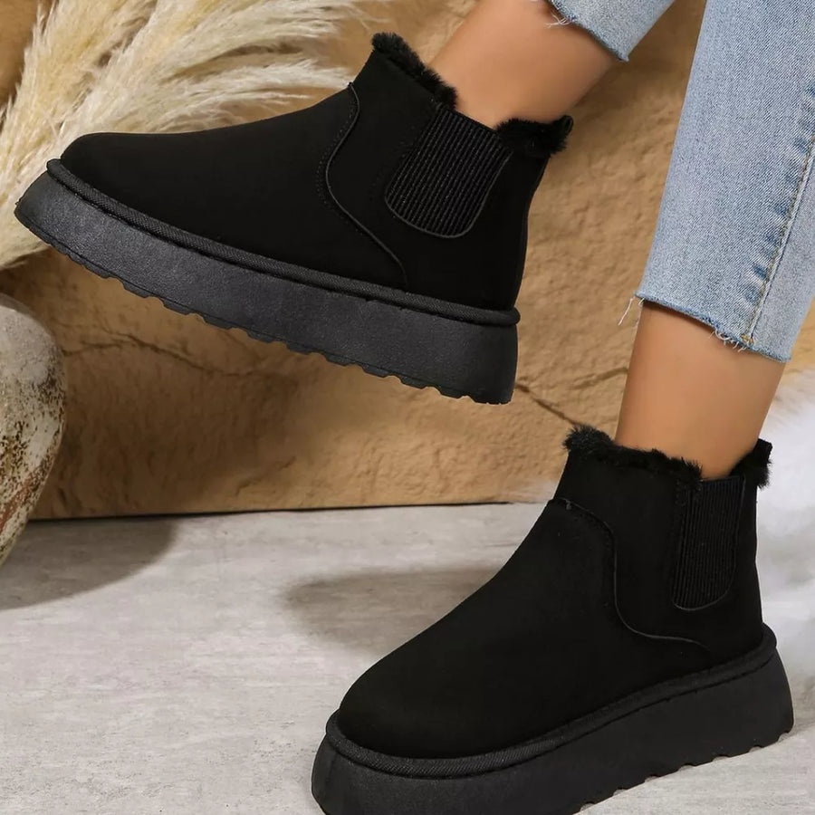 Black suede round toe platform ankle boots with faux fur trim and elastic side panels.