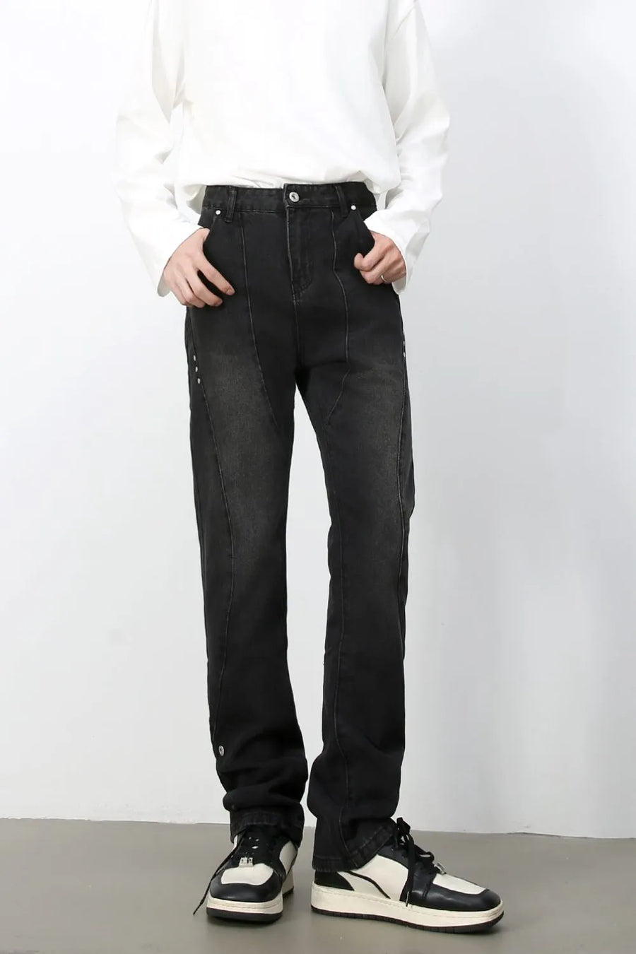 Dark wash denim jeans with asymmetric seams and a straight leg cut.