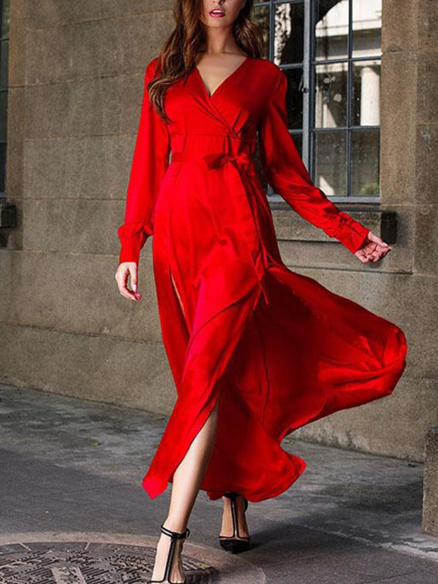 Deep red surplice maxi dress with long sleeves, defined waist tie, and high slit.