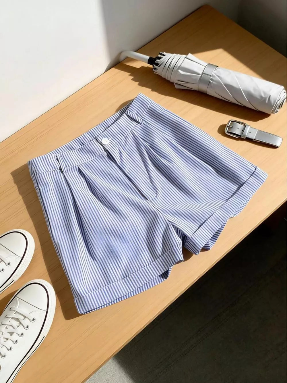 Blue and white striped chino shorts with cuffed hems and a button closure.