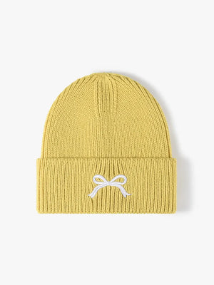 Yellow ribbed knit beanie with embroidered white bow detail