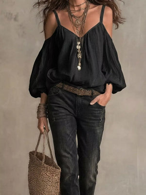Black cold shoulder shirt with balloon sleeves and V-neck, styled with layered necklaces.