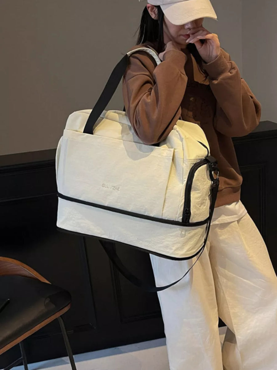 Elegant Oxford cloth travel tote bag in off-white with black trim and shoulder strap.