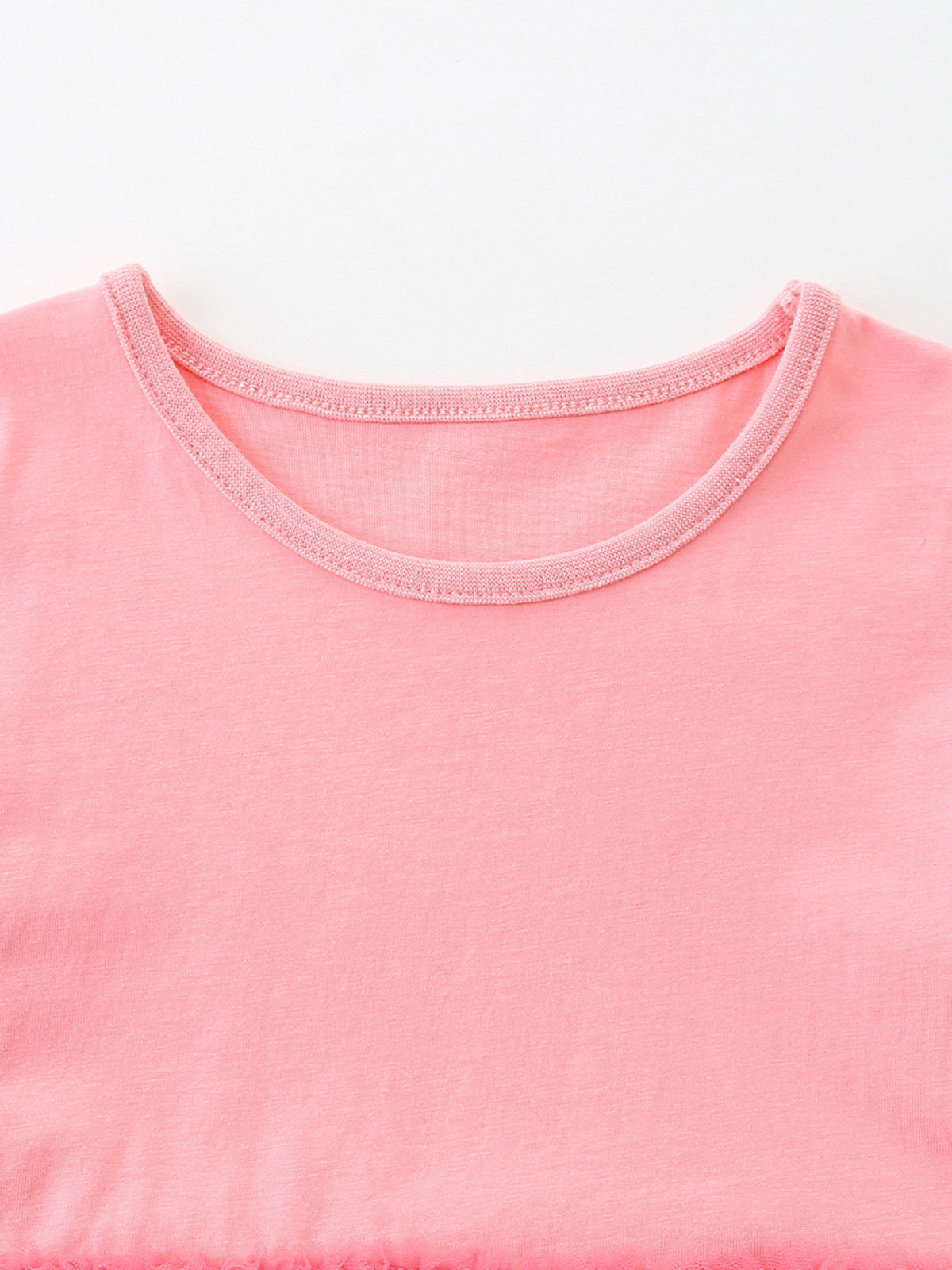 Pink cotton baby dress with a round neckline and ruffled hem detail.