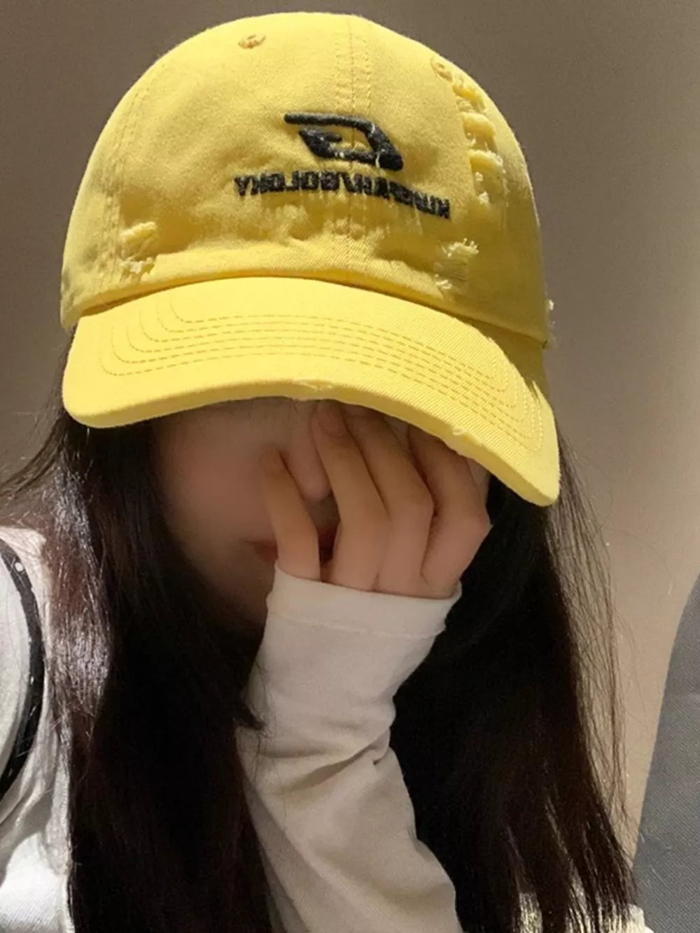Yellow distressed baseball hat with black embroidery and frayed details.