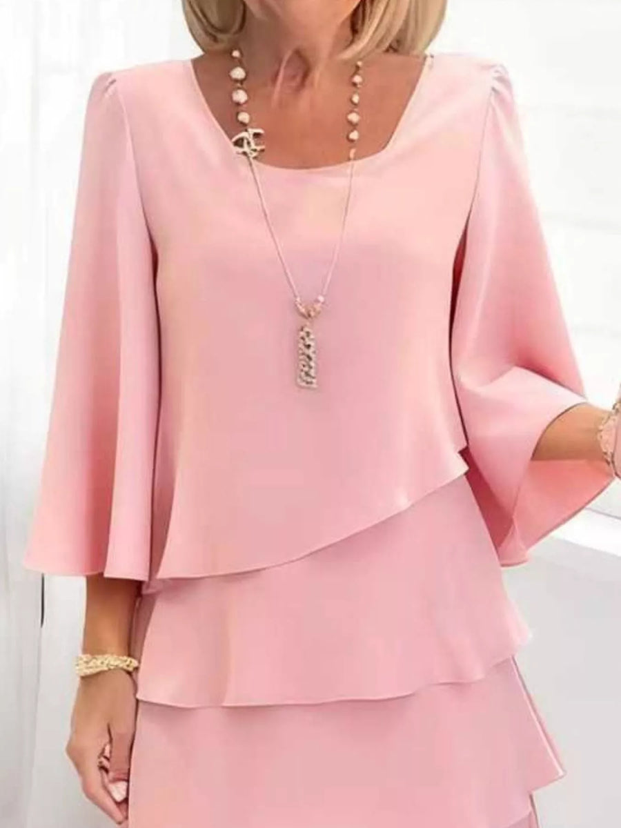 Blush pink tiered dress with 3/4 bell sleeves and a scoop neckline.