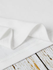 White oversized graphic tee showing fabric texture and stitching detail