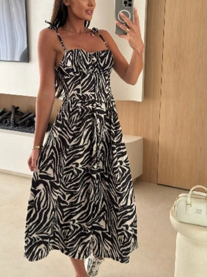 Floral tie-strap midi dress in zebra print with a cinched waist and A-line skirt.