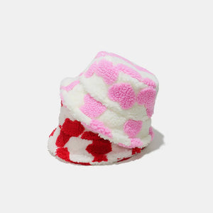 Fuzzy polka dot sherpa bucket hats in pink and deep red.