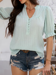 Light green textured puff sleeve blouse with ruffled neckline and button front.