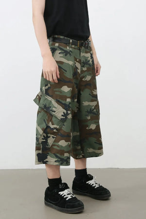 Wide-leg camo cargo Bermuda shorts with multiple pockets and a black belt.