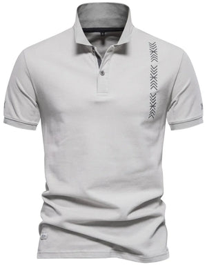 Gray piqué polo shirt with chevron embroidery detail on the chest and sleeve.