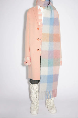 Checked plaid fringed winter wrap in pastel multi-color grid pattern with fringe detail.