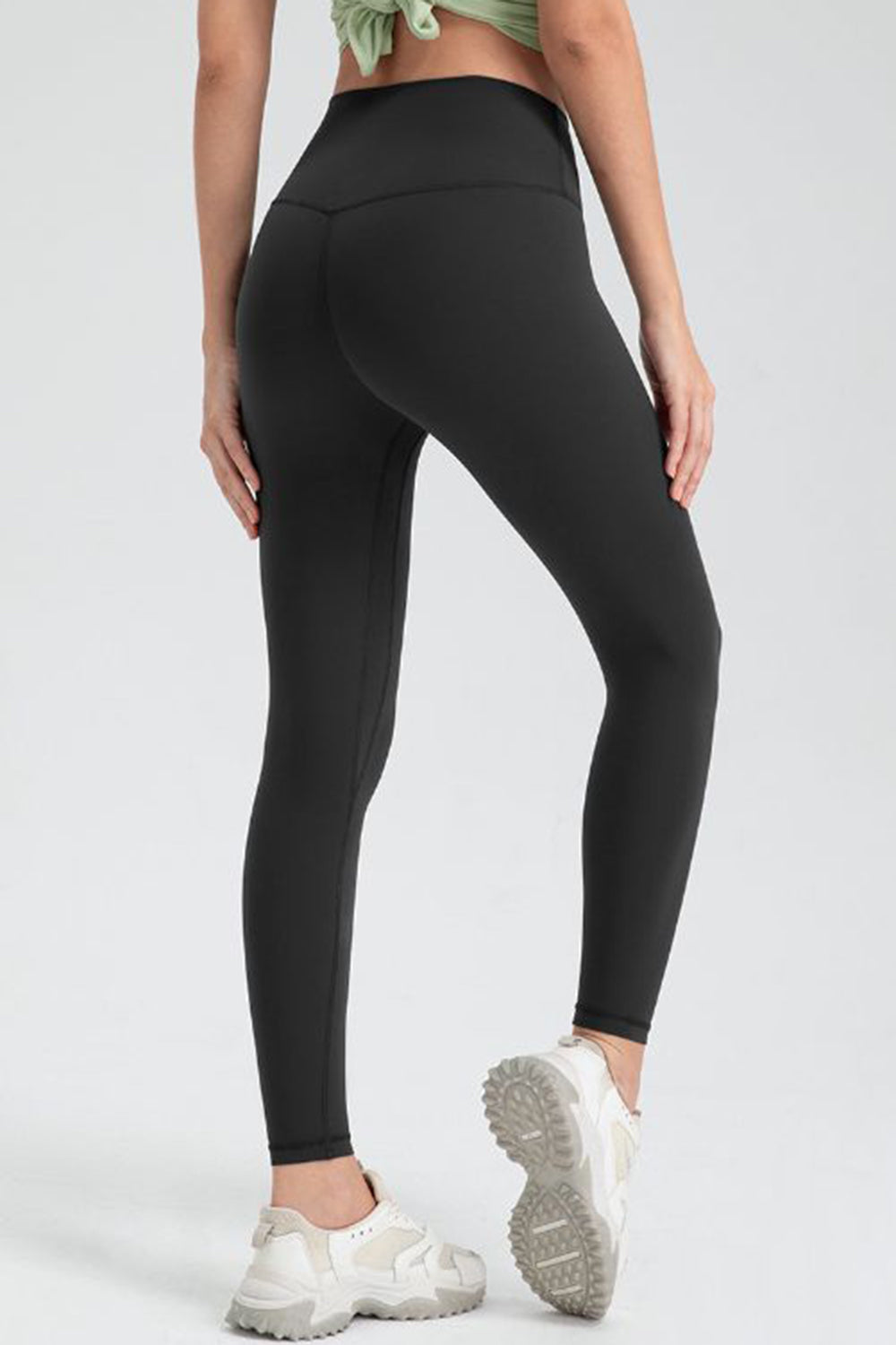 Black high-waist performance leggings with sculpted seams and a V-cut back detail.