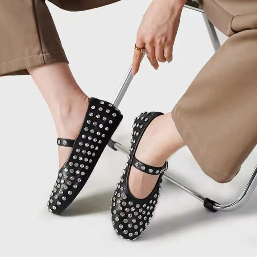 Black studded Mary Jane flats with a strap and buckle detail.