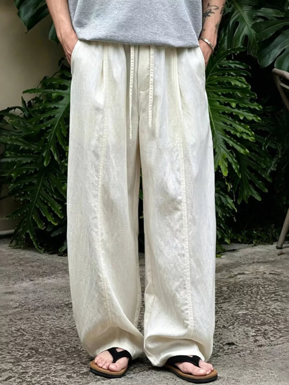 Flax wide-leg sweatpants with drawstring waist and pockets, styled casually.