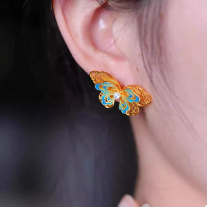 Gold butterfly stud earrings with blue enamel and pearl detail