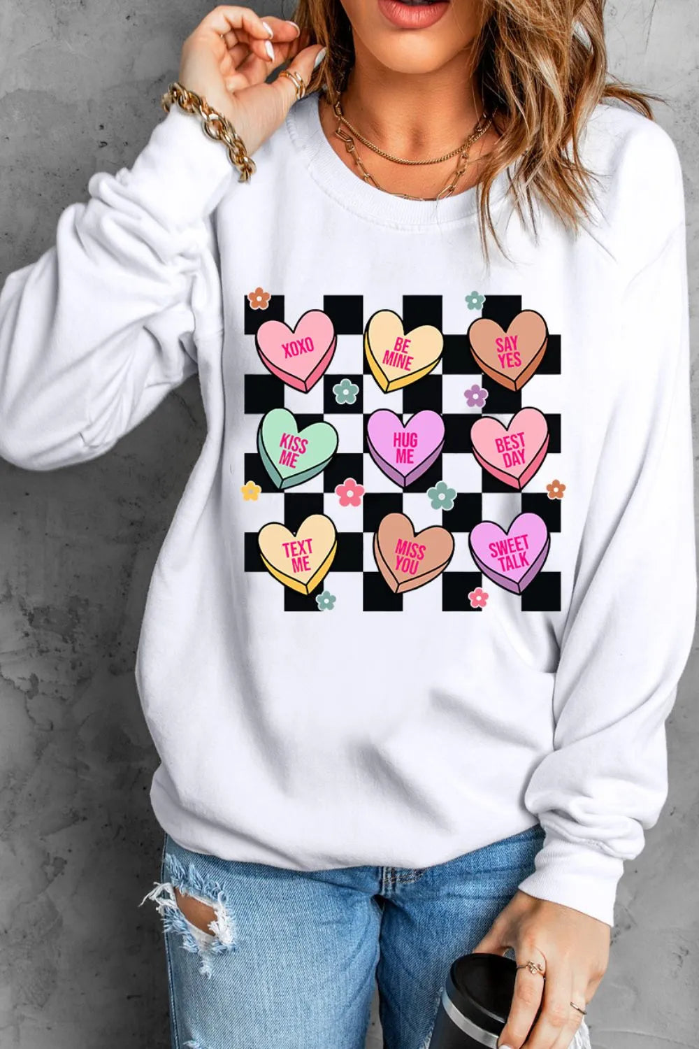 White sweatshirt with conversation heart graphic and checkerboard pattern