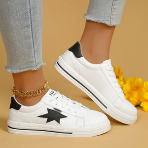 White sneakers with black star patch and black heel detail.