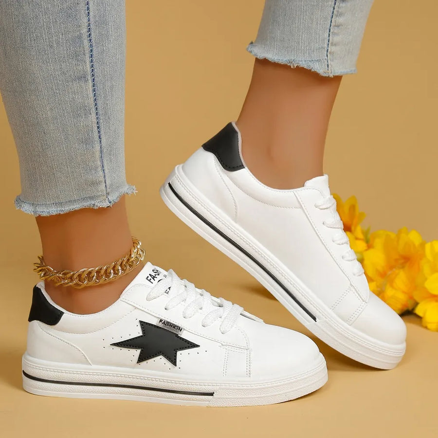 White sneakers with black star patch and black heel detail.