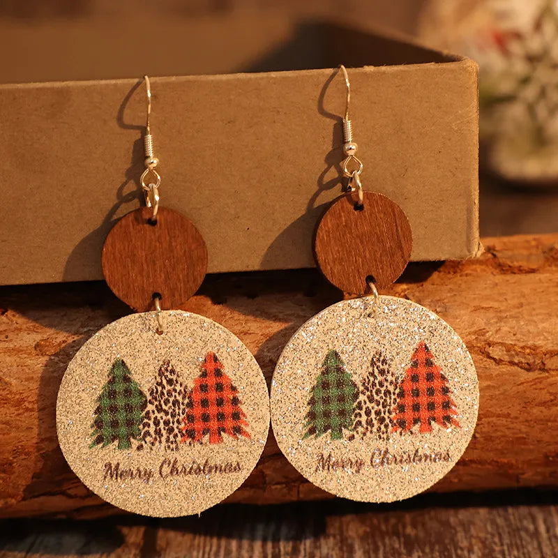 Festive tree print drop earrings with wood accents and Merry Christmas text.