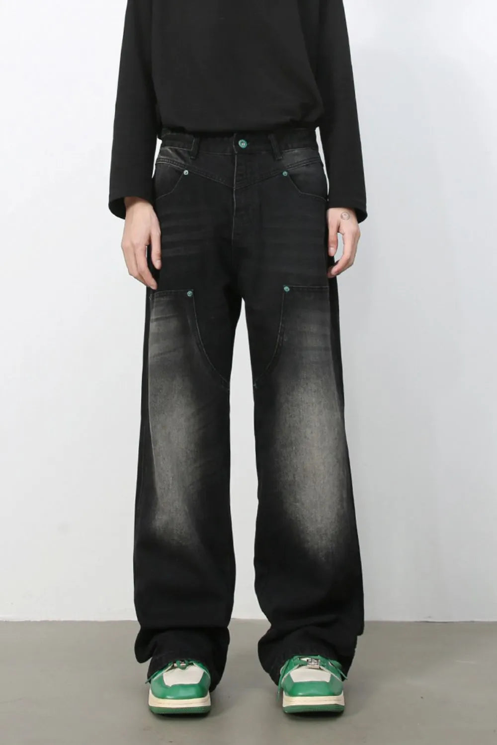 Faded wash wide-leg carpenter jeans in dark black with green button details.