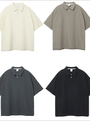 Boxy textured polo shirts in ivory, khaki, dark gray, and black with short sleeves and a two-button placket.