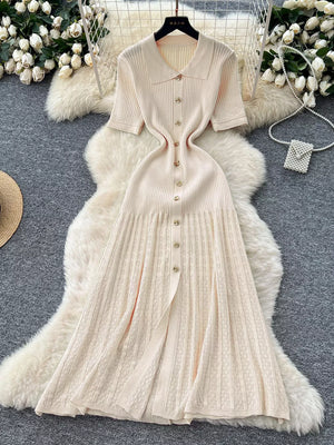 Apricot knit Peter Pan collar dress with gold buttons and a pleated skirt.