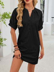 Black cotton dress with notched V-neck, short puff sleeves, and button front.