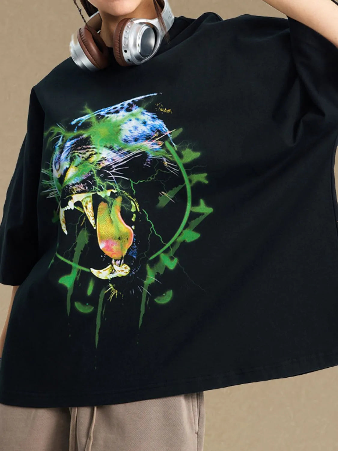 Black oversized t-shirt with a bold electric leopard graphic print and green lightning details.