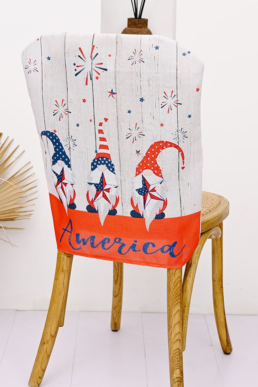 Patriotic gnome chair cover with fireworks and stars, red and blue multicolor fabric.
