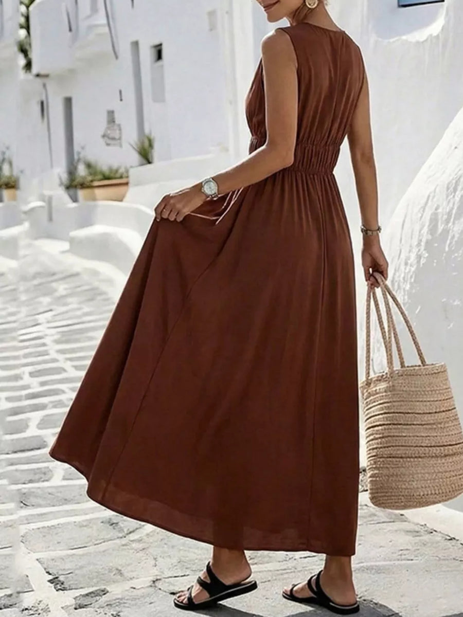 Brown V-neck sleeveless maxi dress with elastic waist and flowing skirt.
