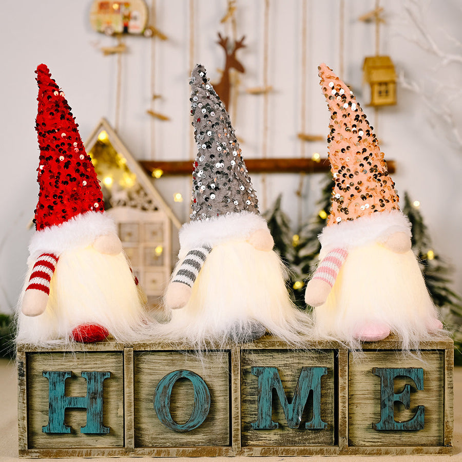Light-Up Sequin Gnome Trio in red, gray, and blush pink with fluffy beards on HOME blocks.