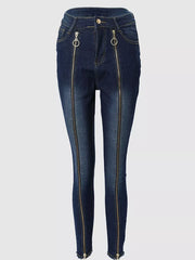 Dark blue skinny jeans with full-length front zippers and ring pulls.