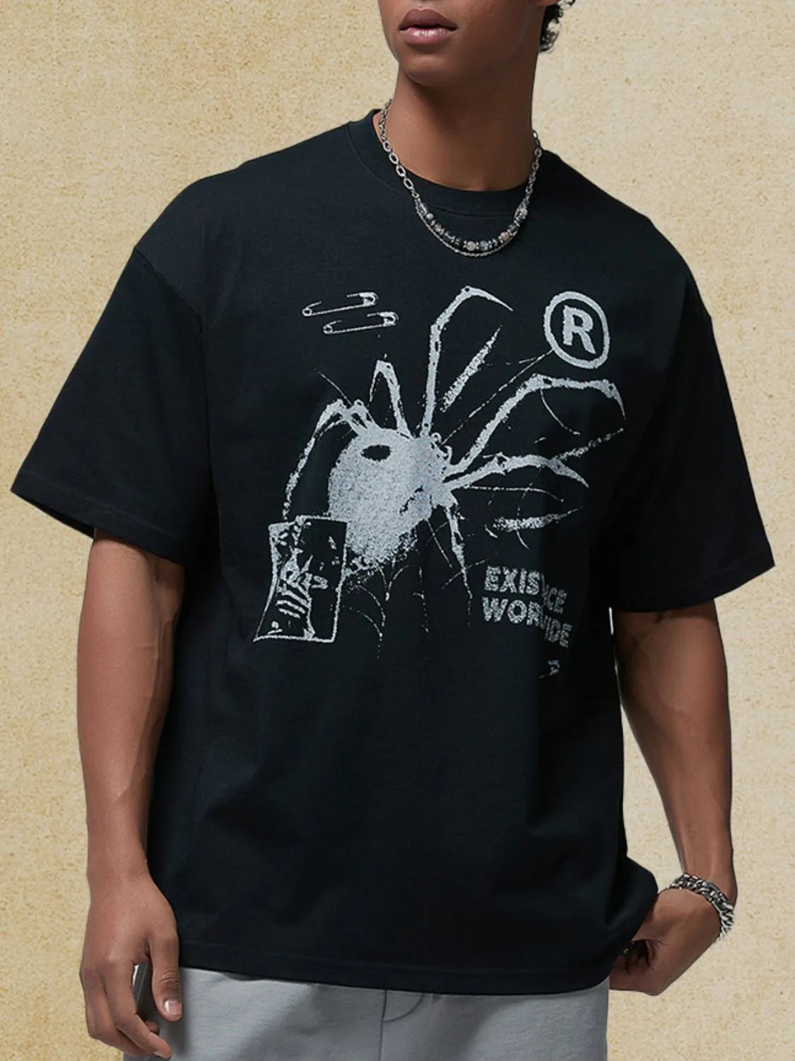 Black oversized graphic tee with spider, safety pins, and text print