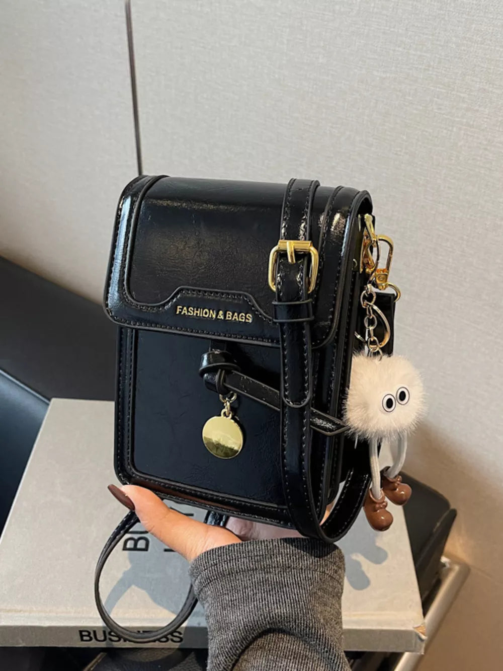 Black pu leather crossbody bag with gold buckle and charm