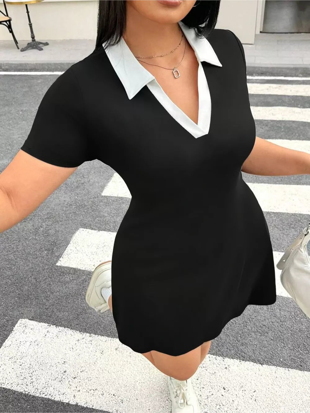 Black bodycon mini dress with short sleeves and a contrast white collar.