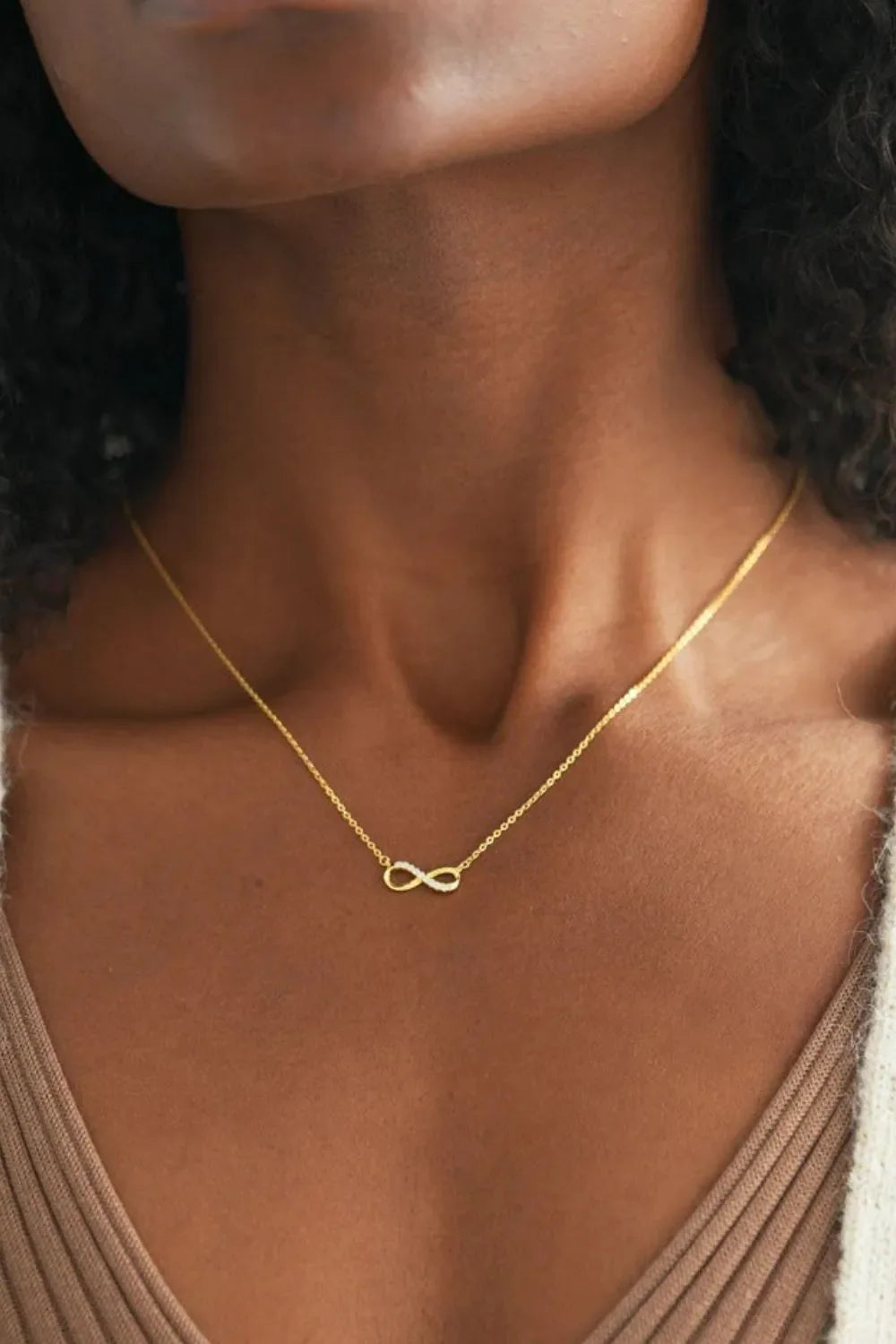 Gold infinity symbol pendant necklace with delicate chain.