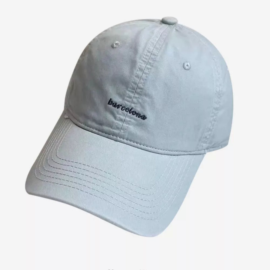 Light blue baseball cap with embroidered "barcelona" text and stitched brim.
