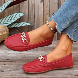 Red round-toe loafers with gold chain detail and stitched trim.
