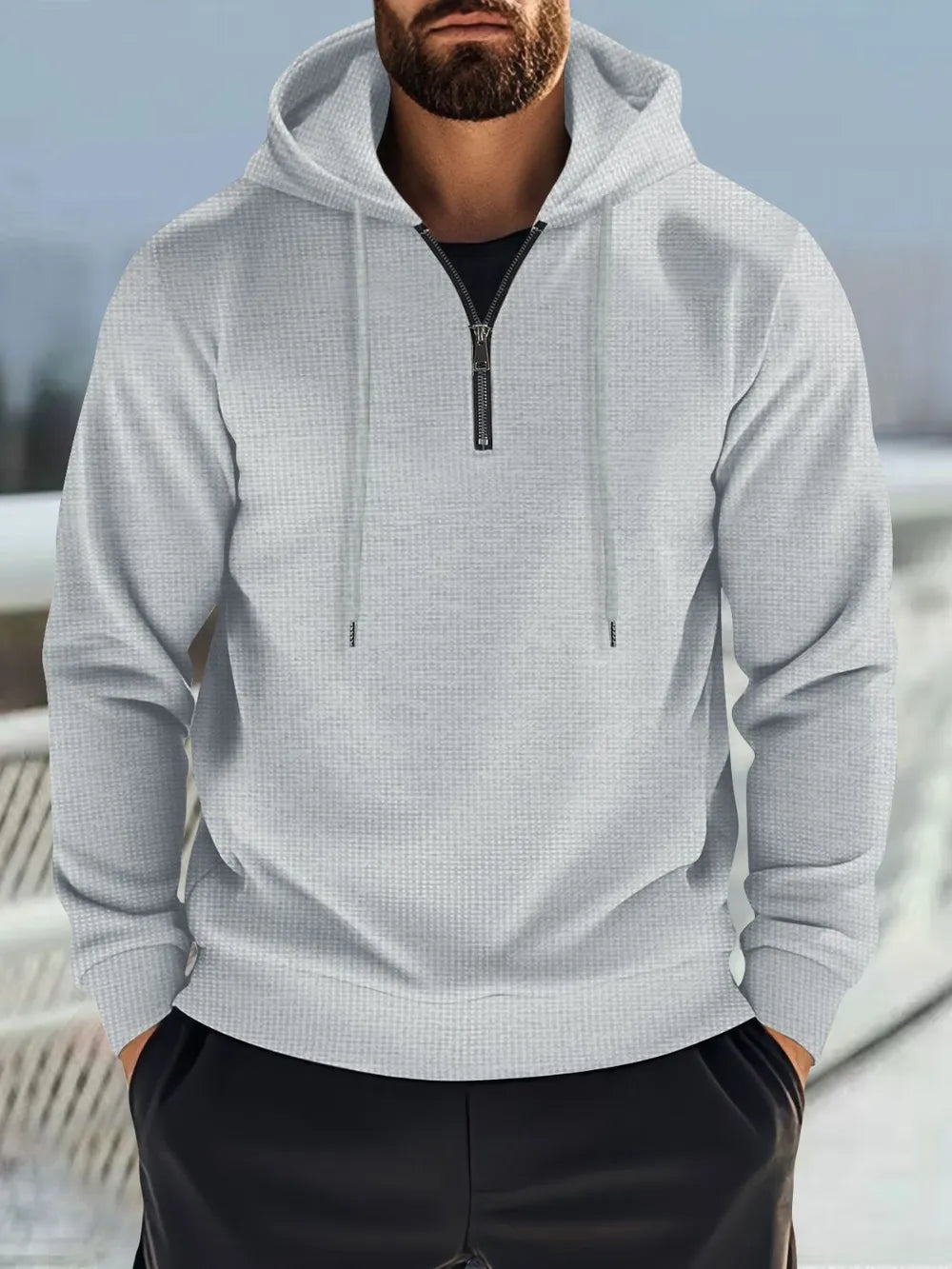 Gray waffle-knit quarter-zip hooded pullover with drawstring and black undershirt.